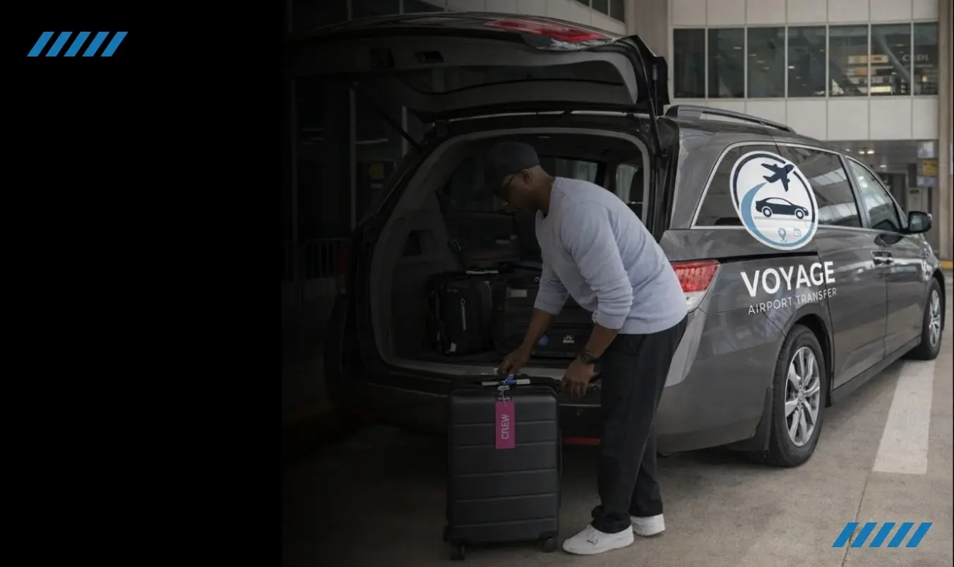 Voyage driver loading luggage into a branded airport-transfer van